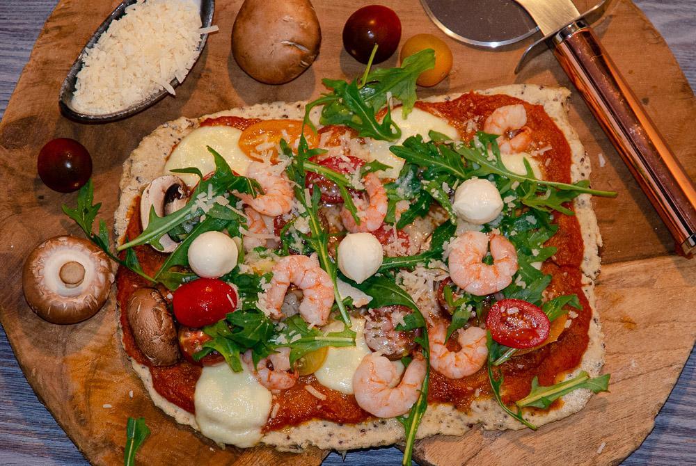 Vegetarische Pizza mit Shrimps, Rucola und Tomaten